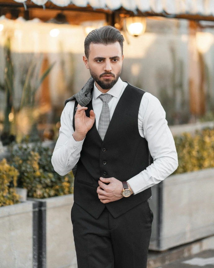 a man in a black vest and tie